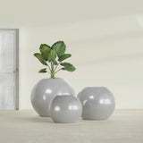 Globe fiberglass planter in Metallic Silver, size range, in a sunlit interior