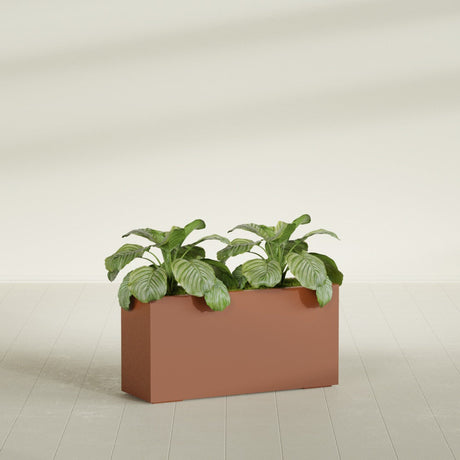 Miami Corner fiberglass planter in Matte Terra Cotta, shown planted, in a sunlit interior
