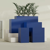 Darwin Corner fiberglass planter in Matte Cobalt Blue, size range, in a sunlit interior