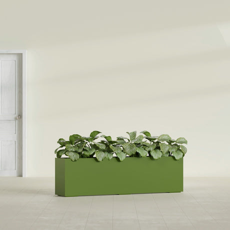 Hudson Extra Long fiberglass planter in Satin Green, shown planted, in a sunlit interior
