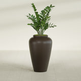 Barà Jar fiberglass planter in Matte Dark Brown, shown planted, in a sunlit interior