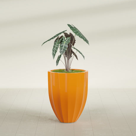 Alicante Fluted fiberglass planter in Gloss Tangerine, shown planted, in a sunlit interior