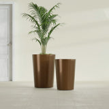 Tegel Round Tapered fiberglass planter in Metallic Bronze, size range, in a sunlit interior