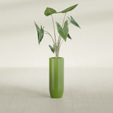 Saint Tropez Bullet Round fiberglass planter in Satin Green, shown planted, in a sunlit interior