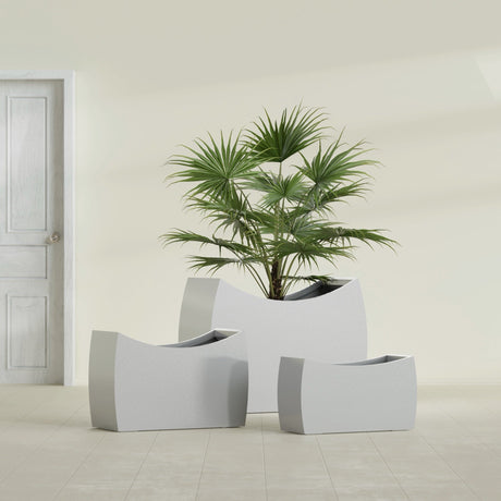 Seoul Curved fiberglass planter in Metallic Silver, size range, in a sunlit interior