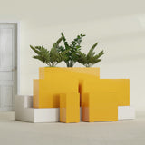 Potsdam Corner fiberglass planter in Gloss Saffron, size range, in a sunlit interior