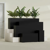 Hollywood Corner fiberglass planter in Matte Black, size range, in a sunlit interior