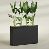 Amesbury Narrow fiberglass planter in Matte Black, planted, in a sunlit interior