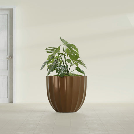 Santa Barbara Fluted Round fiberglass planter in Metallic Bronze, shown planted, in a sunlit interior