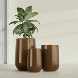 Hayden Urn fiberglass planter in Metallic Bronze, size range, in a sunlit interior