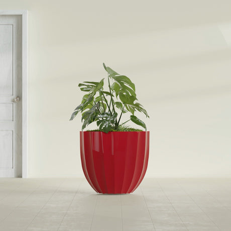 Santa Barbara Fluted Round fiberglass planter in Gloss Red, shown planted, in a sunlit interior