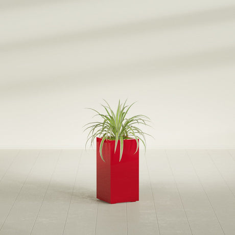 Hollywood Corner fiberglass planter in Gloss Red, shown planted, in a sunlit interior