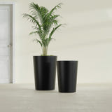 Tegel Round Tapered fiberglass planter in Matte Black, size range, in a sunlit interior
