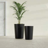 Tegel Round Tapered fiberglass planter in Matte Black, size range, in a sunlit interior