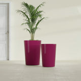 Tegel Round Tapered fiberglass planter in Gloss Eggplant, size range, in a sunlit interior