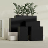 Darwin Corner fiberglass planter in Matte Black, size range, in a sunlit interior