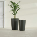 Tegel Round Tapered fiberglass planter in Matte Charcoal, size range, in a sunlit interior