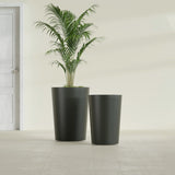 Tegel Round Tapered fiberglass planter in Matte Charcoal, size range, in a sunlit interior