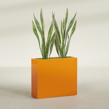 Perth Rectangular fiberglass planter in Gloss Tangerine, shown planted, in a sunlit interior