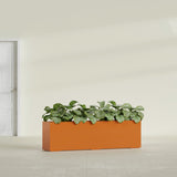 Hudson Extra Long fiberglass planter in Gloss Tangerine, shown planted, in a sunlit interior