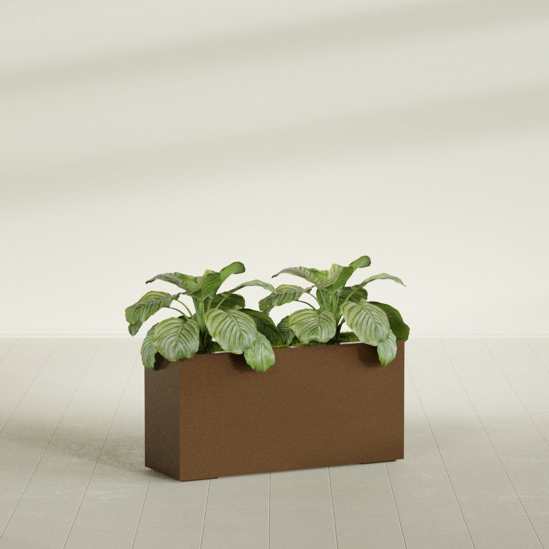 Miami Narrow Rectangular fiberglass planter in Metallic Bronze, shown planted, in a sunlit interior