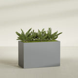 Brisbane Corner fiberglass planter in Matte Gunmetal, shown planted, in a sunlit interior