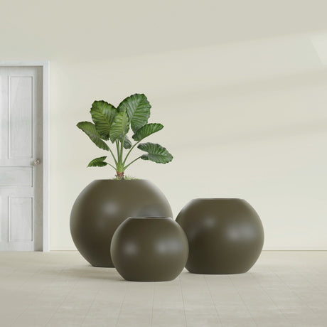 Globe fiberglass planter in Matte Bronze, size range, in a sunlit interior