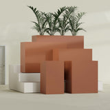 Darwin Corner fiberglass planter in Matte Terra Cotta, size range, in a sunlit interior