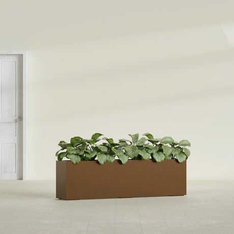 Hudson Extra Long fiberglass planter in Metallic Bronze, shown planted, in a sunlit interior
