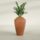 Barà Jar fiberglass planter in Matte Terra Cotta, shown planted, in a sunlit interior