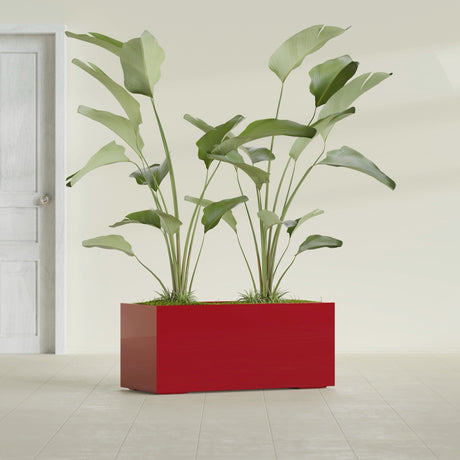 Badalona Rectangular fiberglass planter in Gloss Red, shown planted, in a sunlit interior