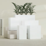 Darwin Corner fiberglass planter in Gloss Bright White, size range, in a sunlit interior