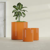Rio Grande Cylinder fiberglass planter in Gloss Tangerine, size range, in a sunlit interior