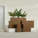Potsdam Corner fiberglass planter in Metallic Bronze, size range, in a sunlit interior