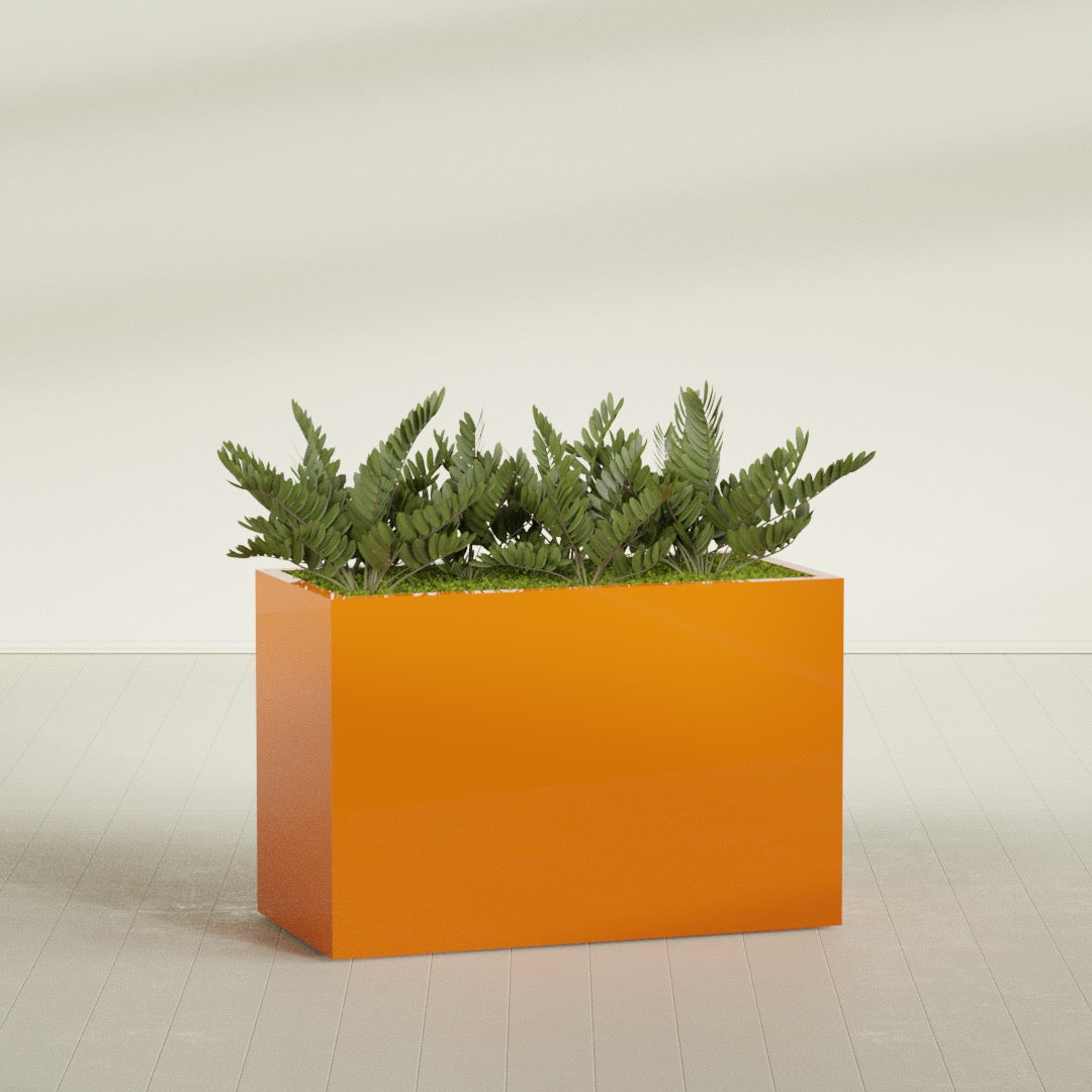Brisbane Rectangular fiberglass planter in Gloss Tangerine, shown planted, in a sunlit interior