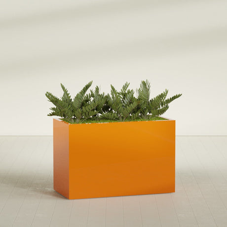 Brisbane Rectangular fiberglass planter in Gloss Tangerine, shown planted, in a sunlit interior