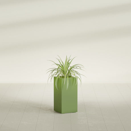 Hollywood Corner fiberglass planter in Satin Green, shown planted, in a sunlit interior