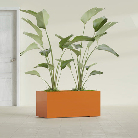 Badalona Rectangular fiberglass planter in Gloss Tangerine, shown planted, in a sunlit interior