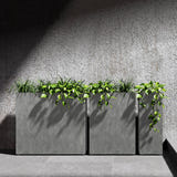 Reglo modular rectangular Cosapots fiberglass planters, shown in a run of three with trailing planting against a concrete wall.