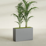 Potsdam Corner fiberglass planter in Matte Gunmetal, shown planted, in a sunlit interior