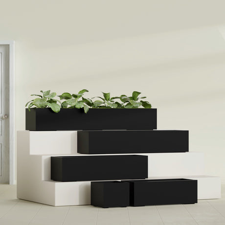 Cuba Corner fiberglass planter in Matte Black, size range, in a sunlit interior