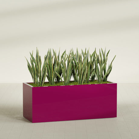 Granada rectangular fiberglass planter in Gloss Eggplant, 60 × 24 × 24 in, shown planted in a room