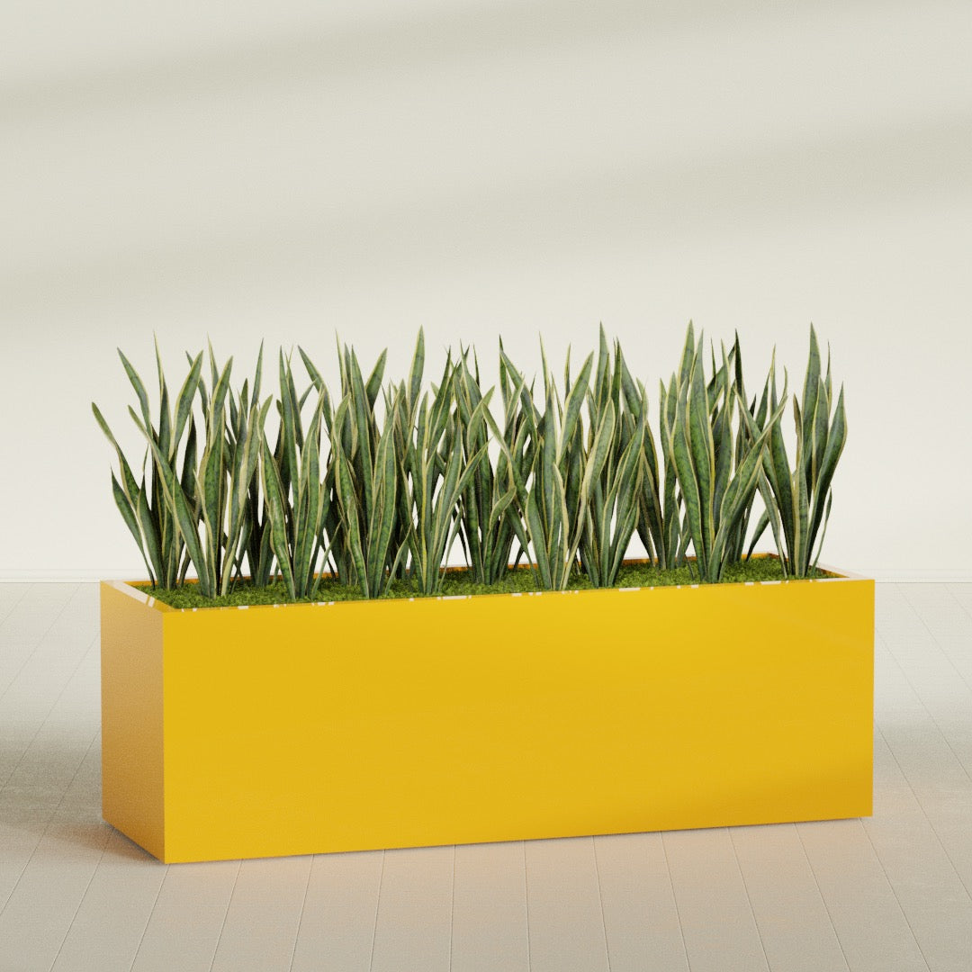 Granada rectangular fiberglass planter in Gloss Saffron, 72 × 24 × 24 in, shown planted in a room