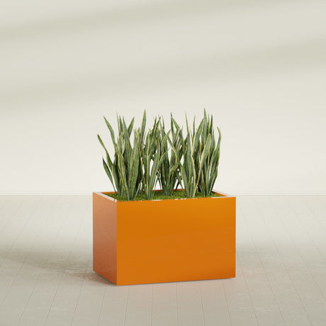 Granada rectangular fiberglass planter in Gloss Tangerine, 36 × 24 × 24 in, shown planted in a room