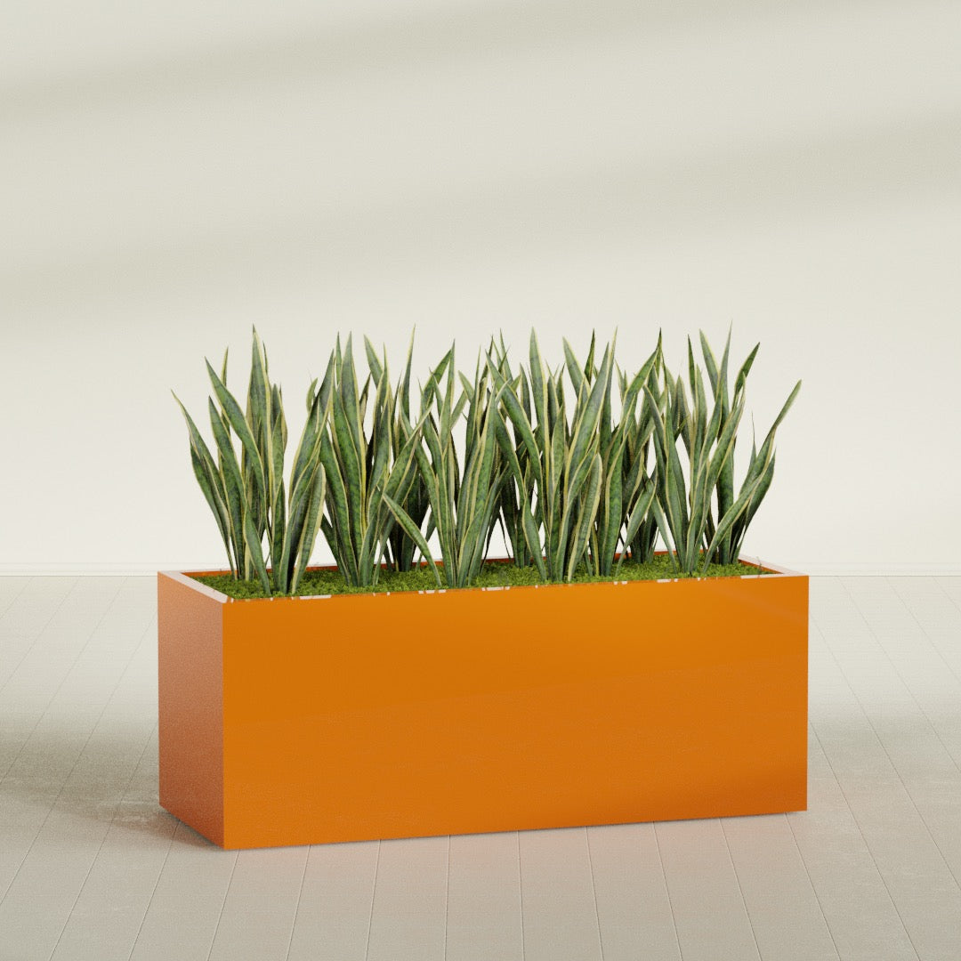 Granada rectangular fiberglass planter in Gloss Tangerine, 60 × 24 × 24 in, shown planted in a room