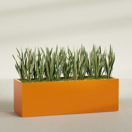 Granada rectangular fiberglass planter in Gloss Tangerine, 72 × 24 × 24 in, shown planted in a room