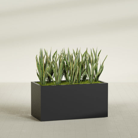 Granada rectangular fiberglass planter in Matte Black, 48 × 24 × 24 in, shown planted in a room