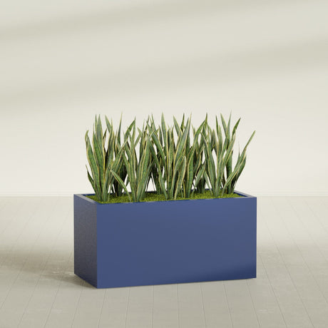 Granada rectangular fiberglass planter in Matte Cobalt Blue, 48 × 24 × 24 in, shown planted in a room