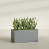 Granada rectangular fiberglass planter in Matte Gunmetal, 48 × 24 × 24 in, shown planted in a room