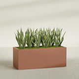 Granada rectangular fiberglass planter in Matte Terra Cotta, 60 × 24 × 24 in, shown planted in a room